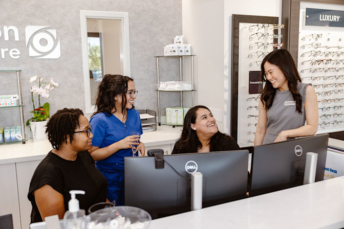 Front office team smiling at optical store
