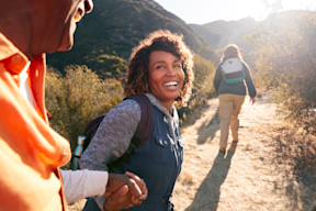 Woman experiencing joy of sight after LASIK eye surgery during hike holding hands happy smiling
