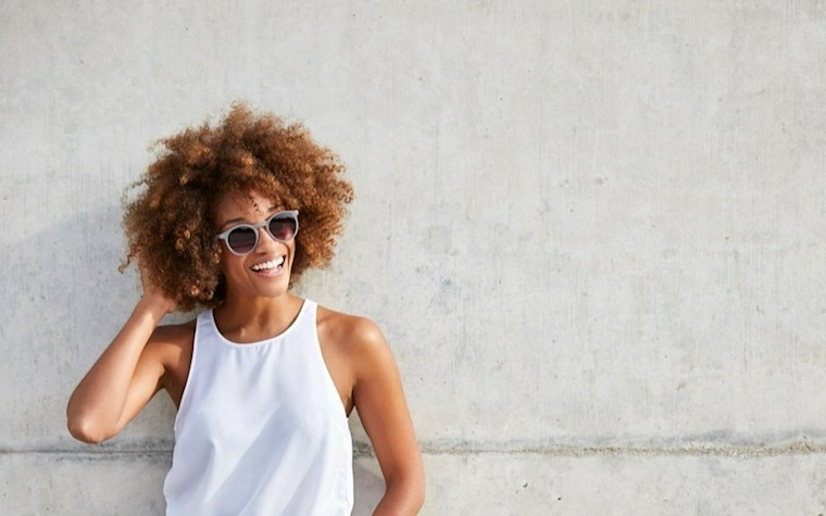 Woman smiling wearing sunglasses after LASIK