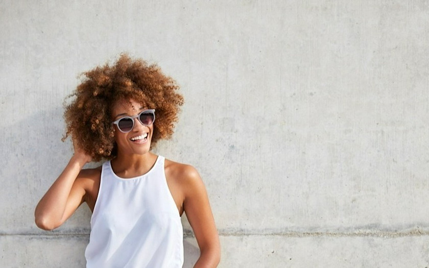 Woman smiling wearing sunglasses after LASIK